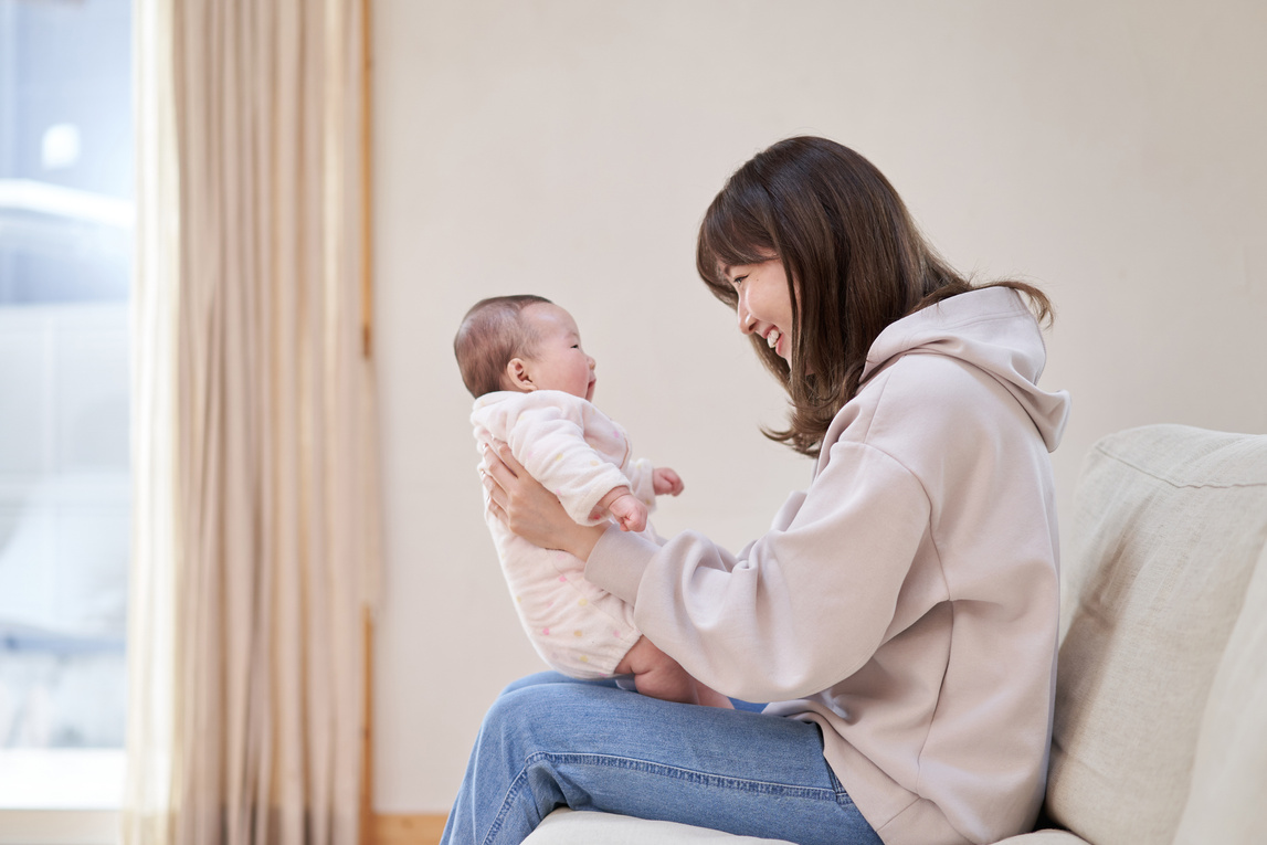 Asian mom making baby laugh