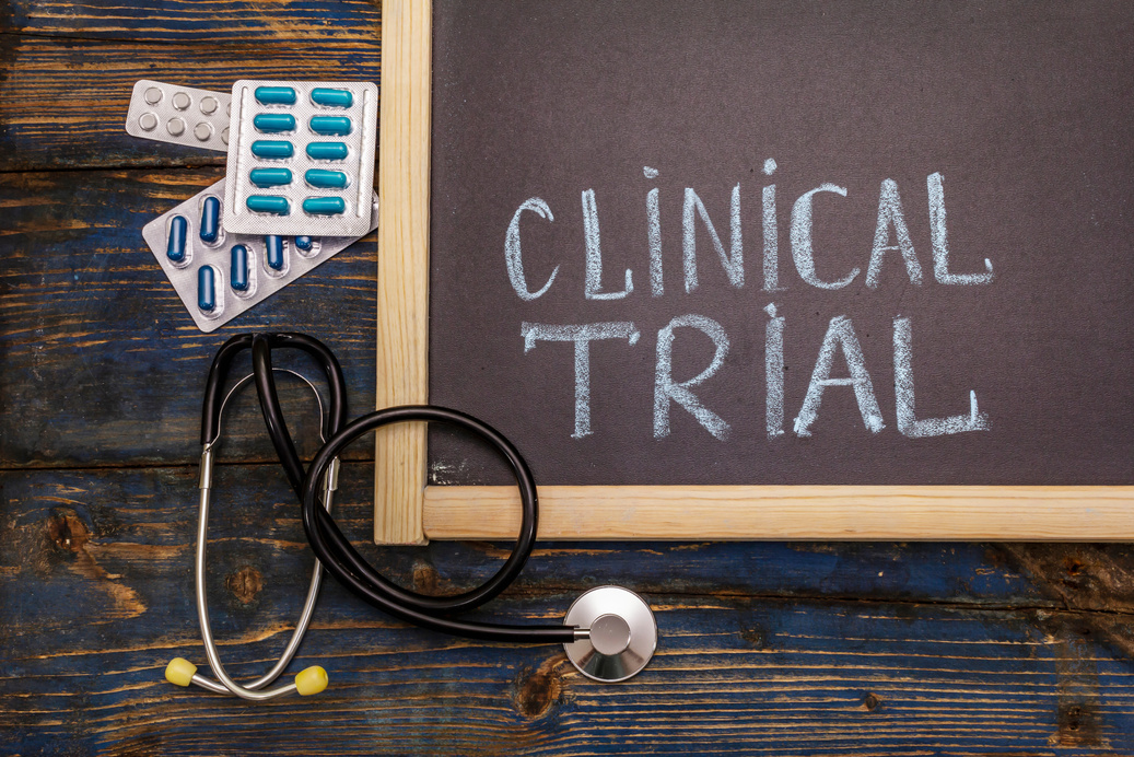 Clinical trial concept. Chalk board, stethoscope, pills