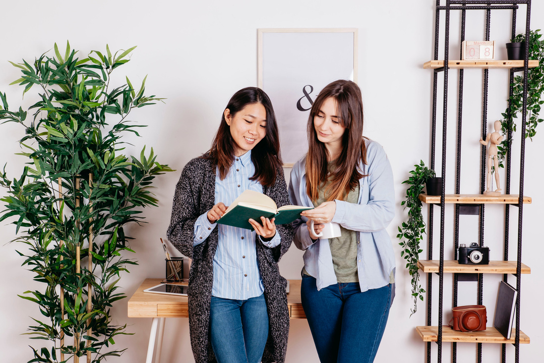 young women sharing book together